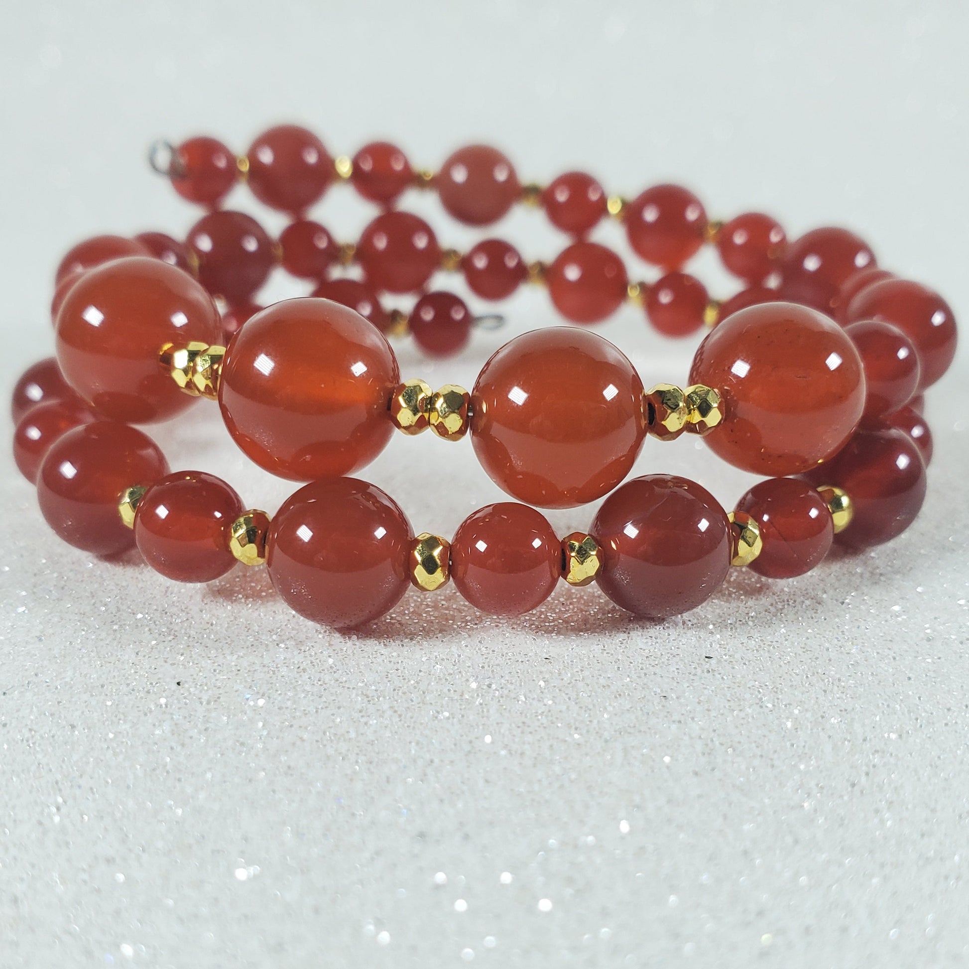 Stacked red beaded bracelet on a light gray background