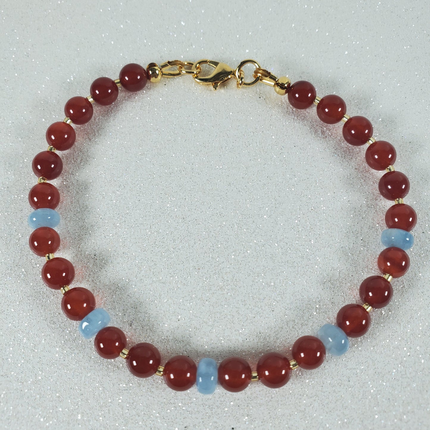 Beaded bracelet with red and blue beads on a light gray background