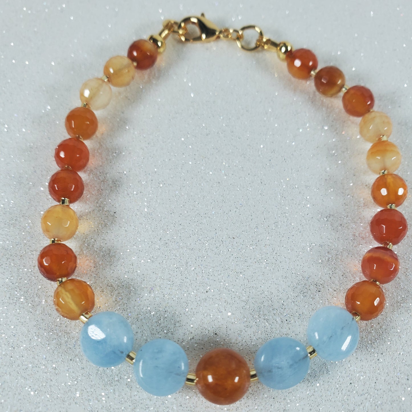Beaded bracelet with red, orange, and blue beads on a white background