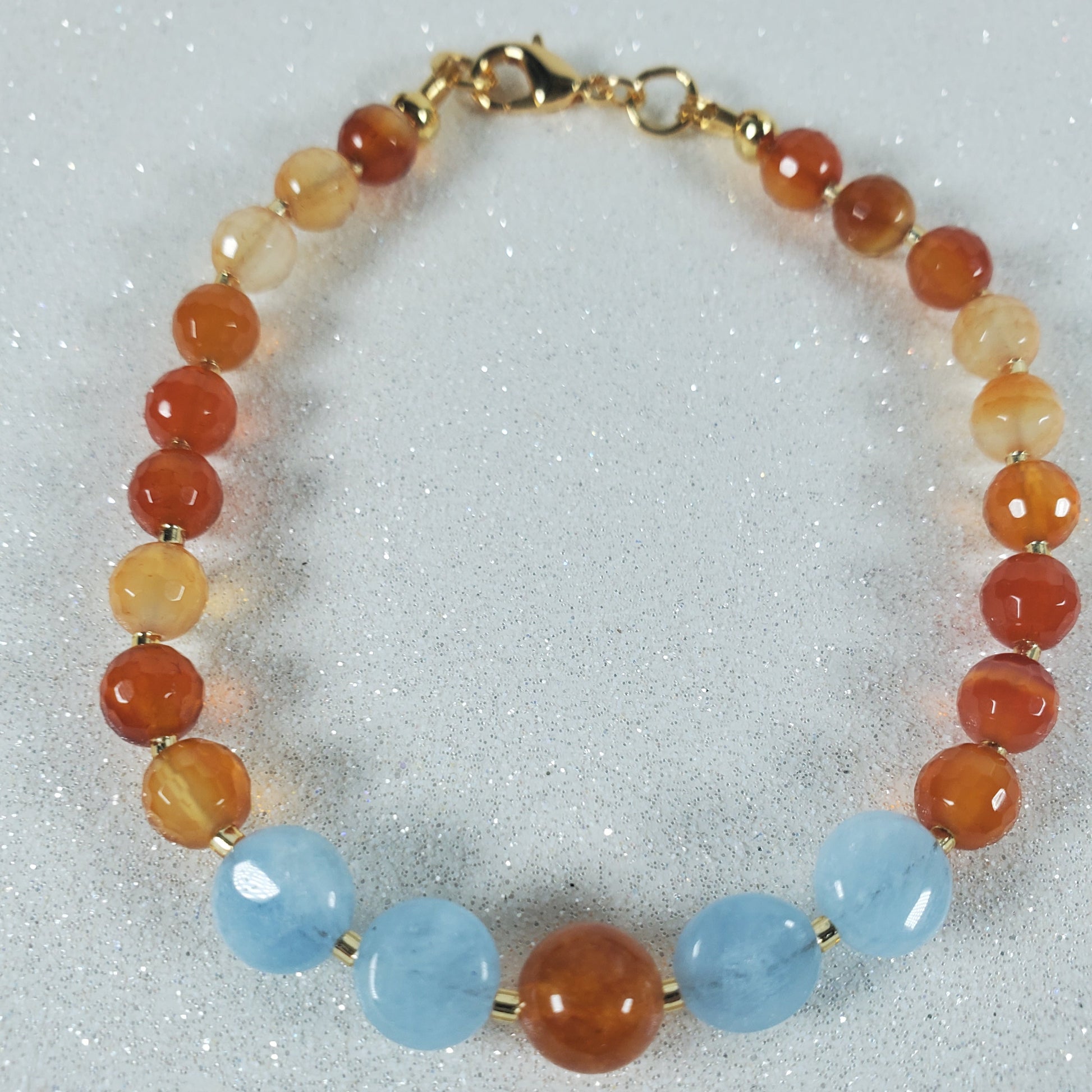 Beaded bracelet with red, orange, and blue beads on a white background