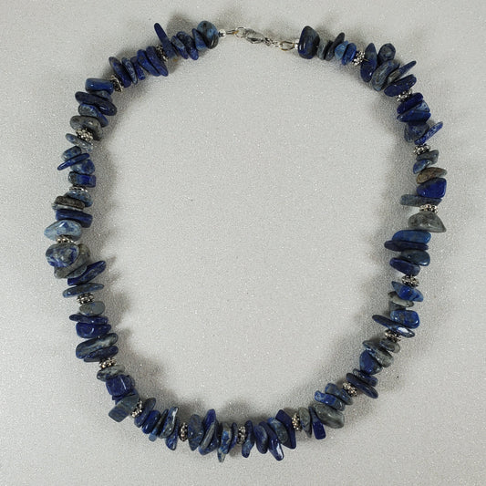 Necklace with blue beads on a light gray background