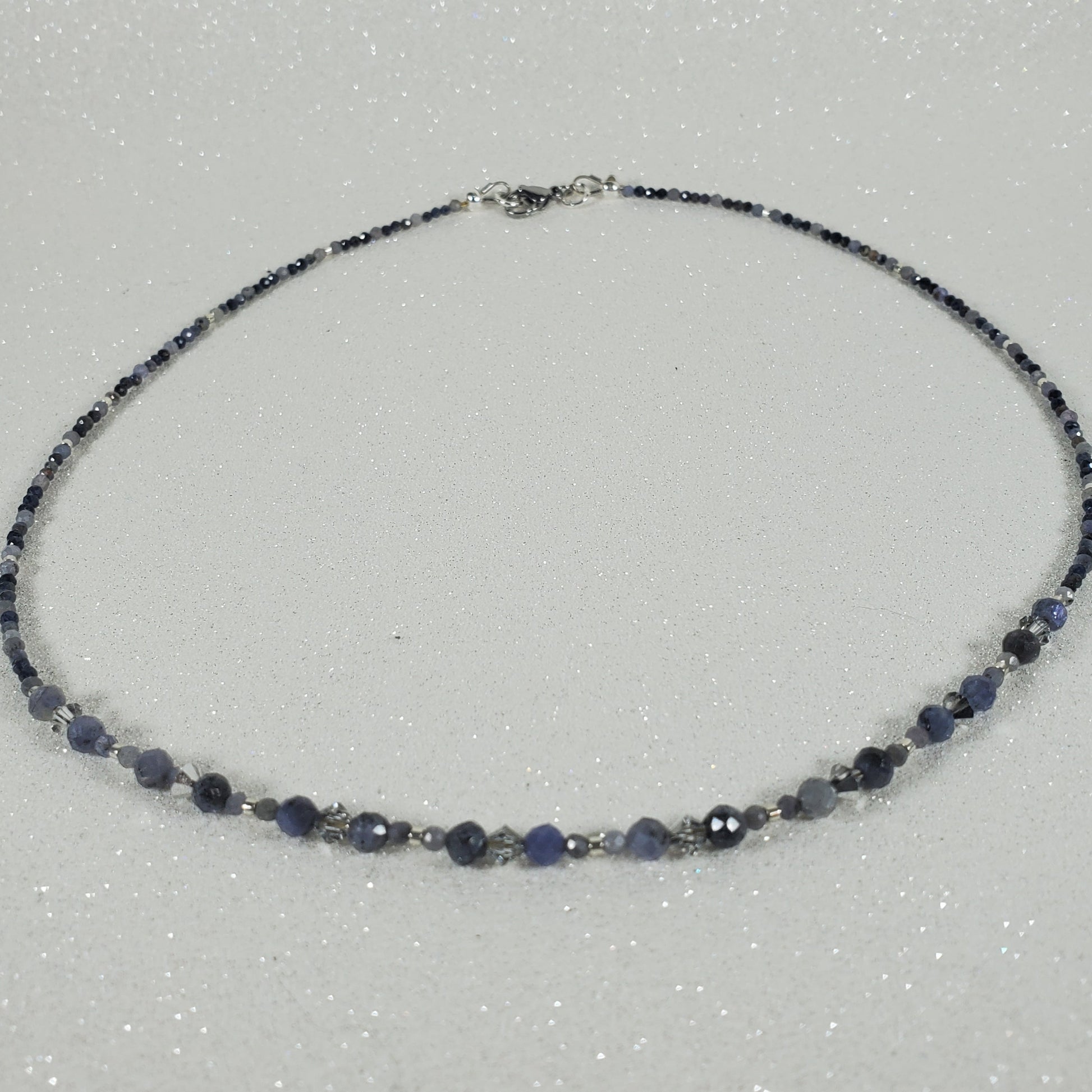 Necklace with blue and silver beads on a light gray background