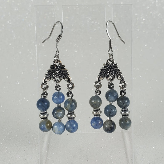 Pair of beaded earrings on a clear card against a light gray background