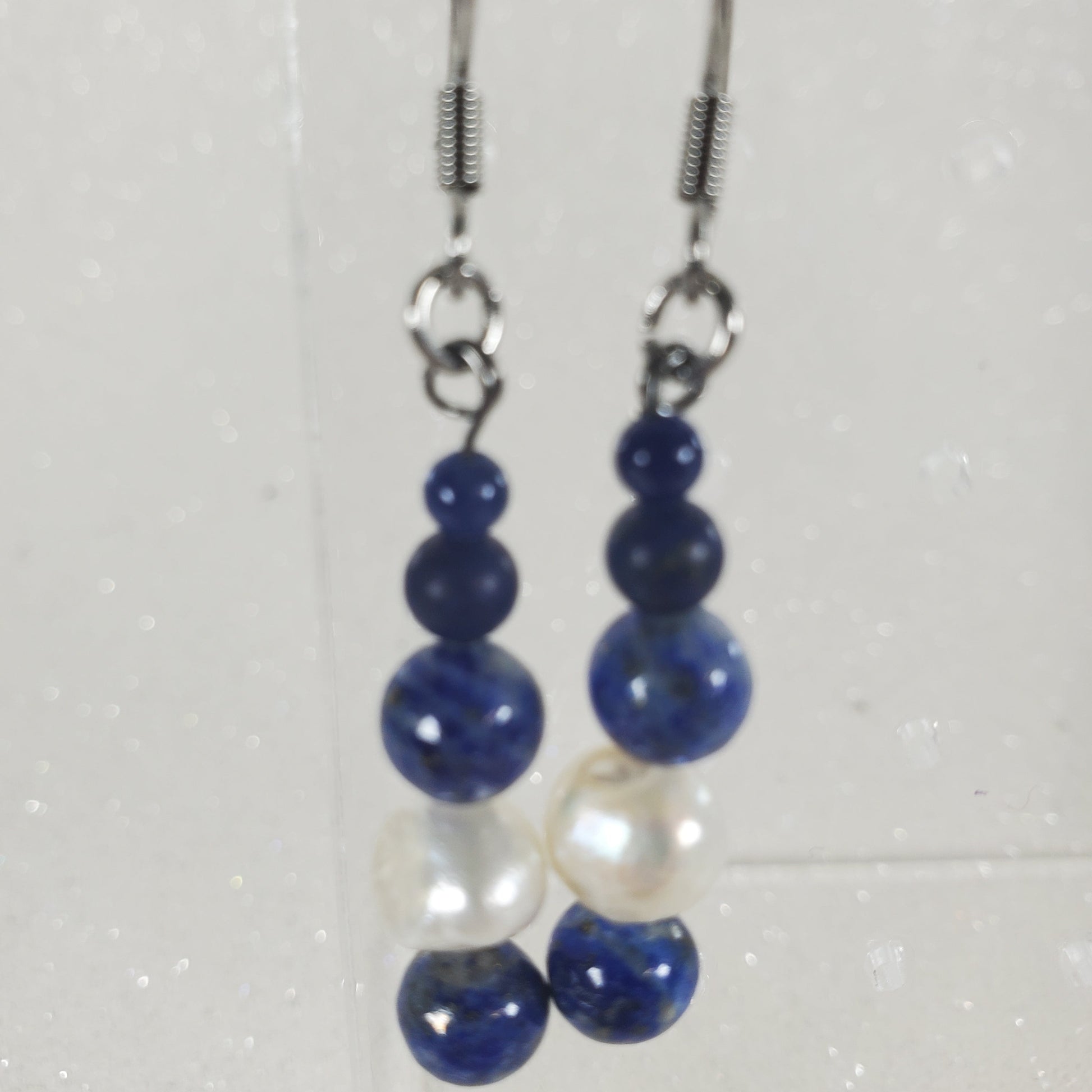 Pair of blue and white beaded earrings on a light gray background