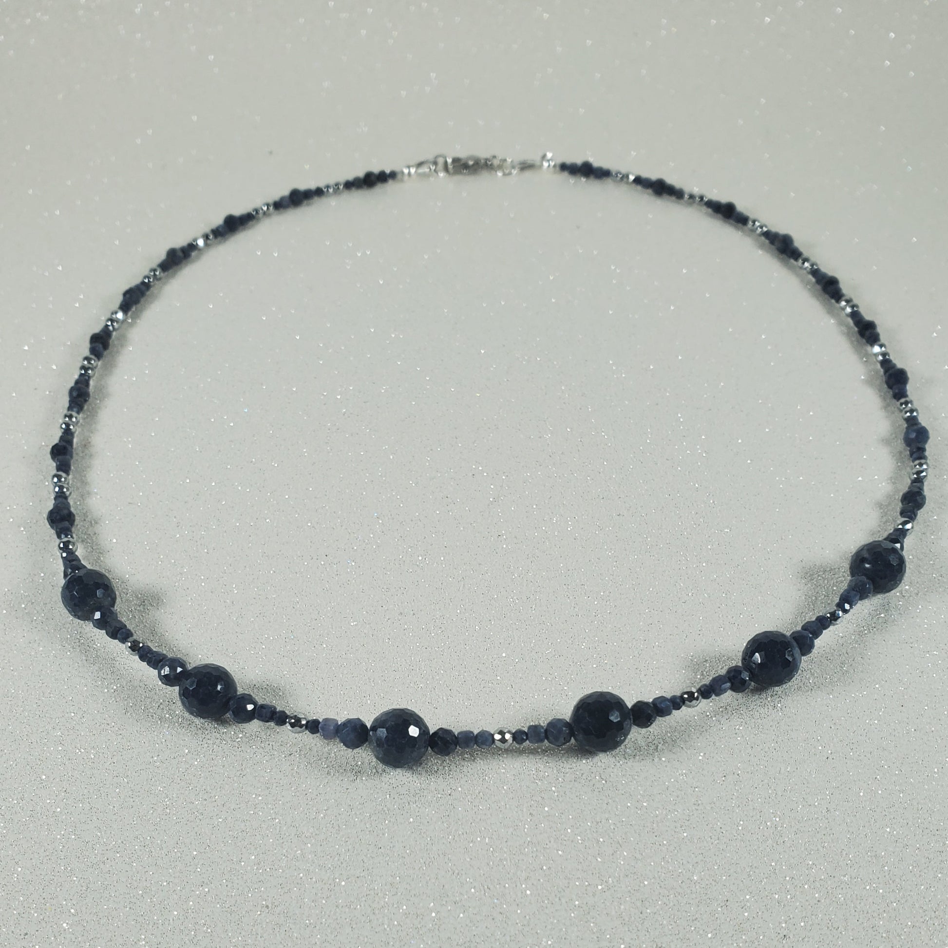 Necklace with dark blue beads on a gray background