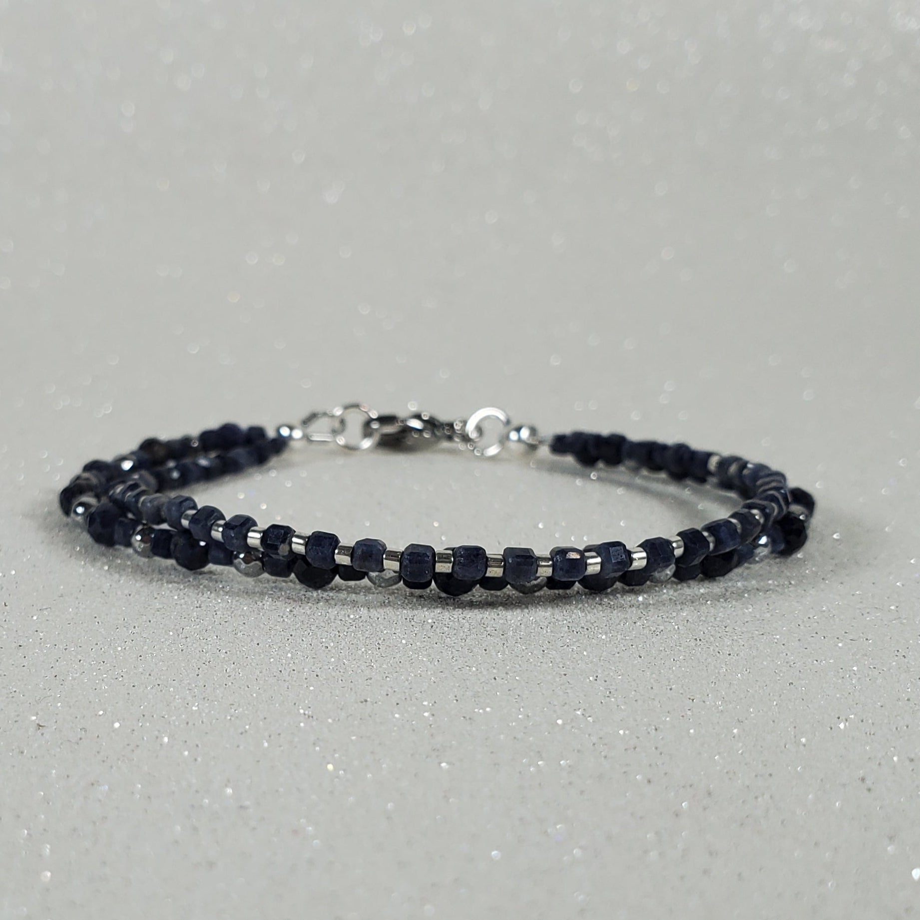 Navy blue beaded bracelet on a gray background
