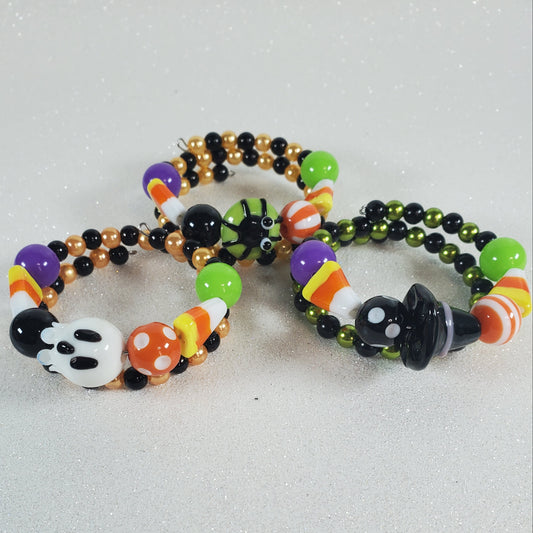 Halloween-themed beaded bracelets with colorful beads on a gray background