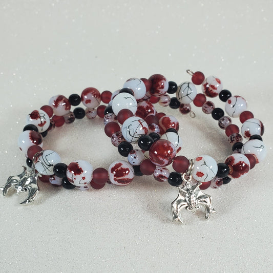 Beaded bracelet with red, white, and black beads on a light gray background