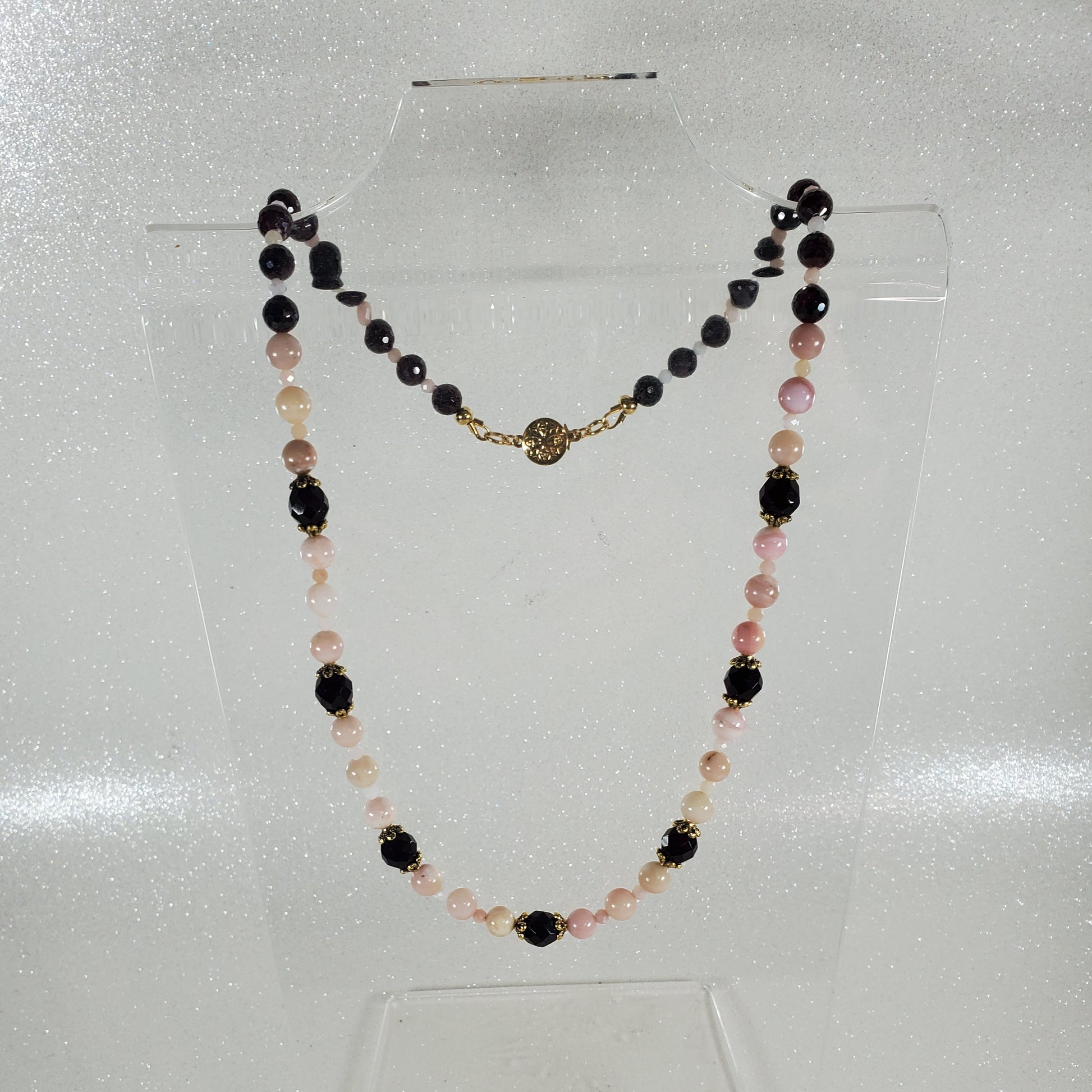 Necklace with deep red and pink beads on a white background