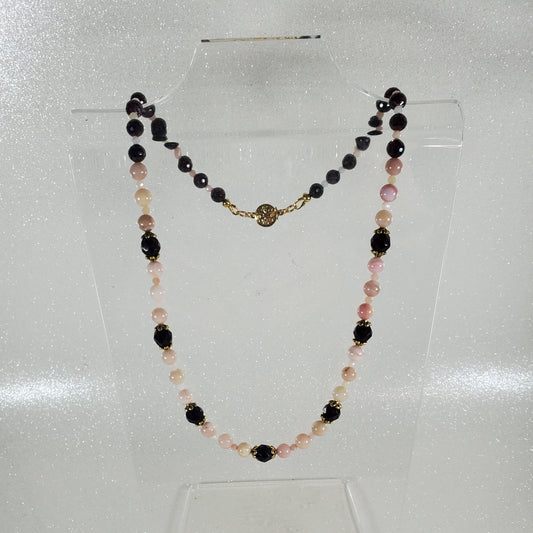 Necklace with deep red and pink beads on a white background