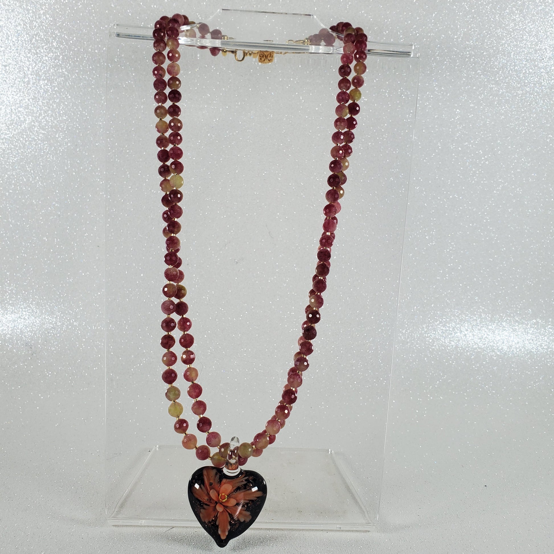 Beaded necklace with a heart-shaped pendant on a white background