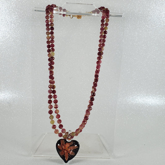 Beaded necklace with a heart-shaped pendant on a white background