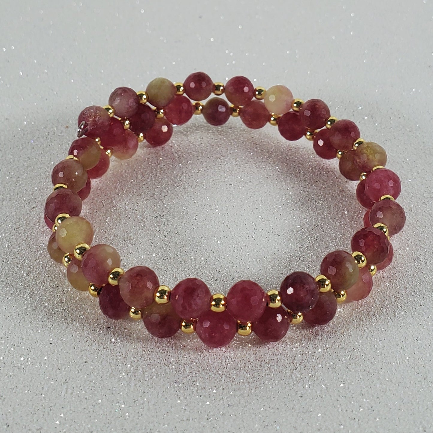 Beaded ring with red and gold beads on a white background