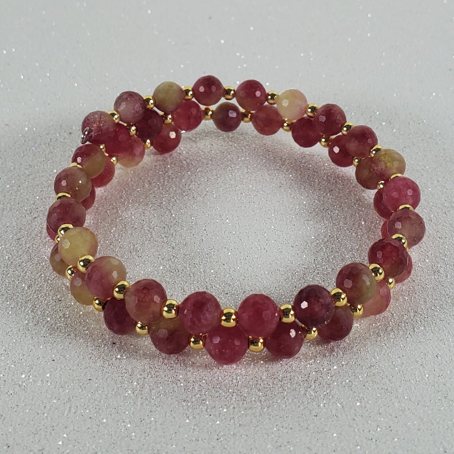 Beaded ring with red and gold beads on a white background