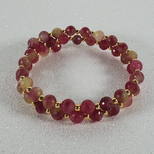Beaded ring with red and gold beads on a white background