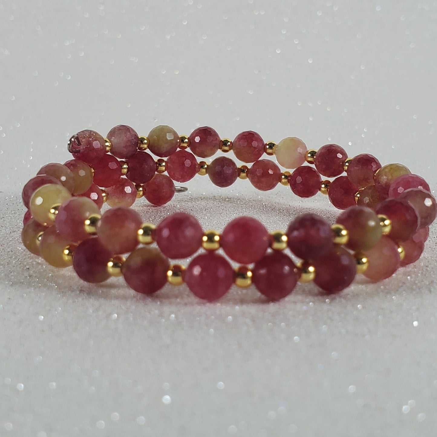 Beaded ring with red and gold beads on a white background