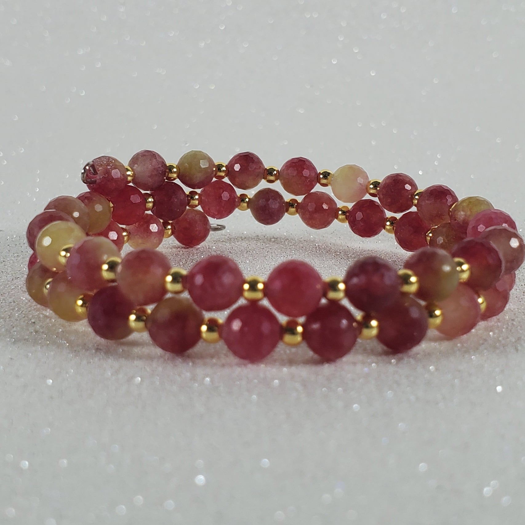 Beaded ring with red and gold beads on a white background
