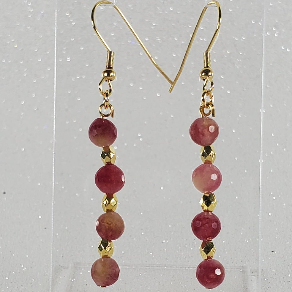 Pair of earrings with red beads on a clear background