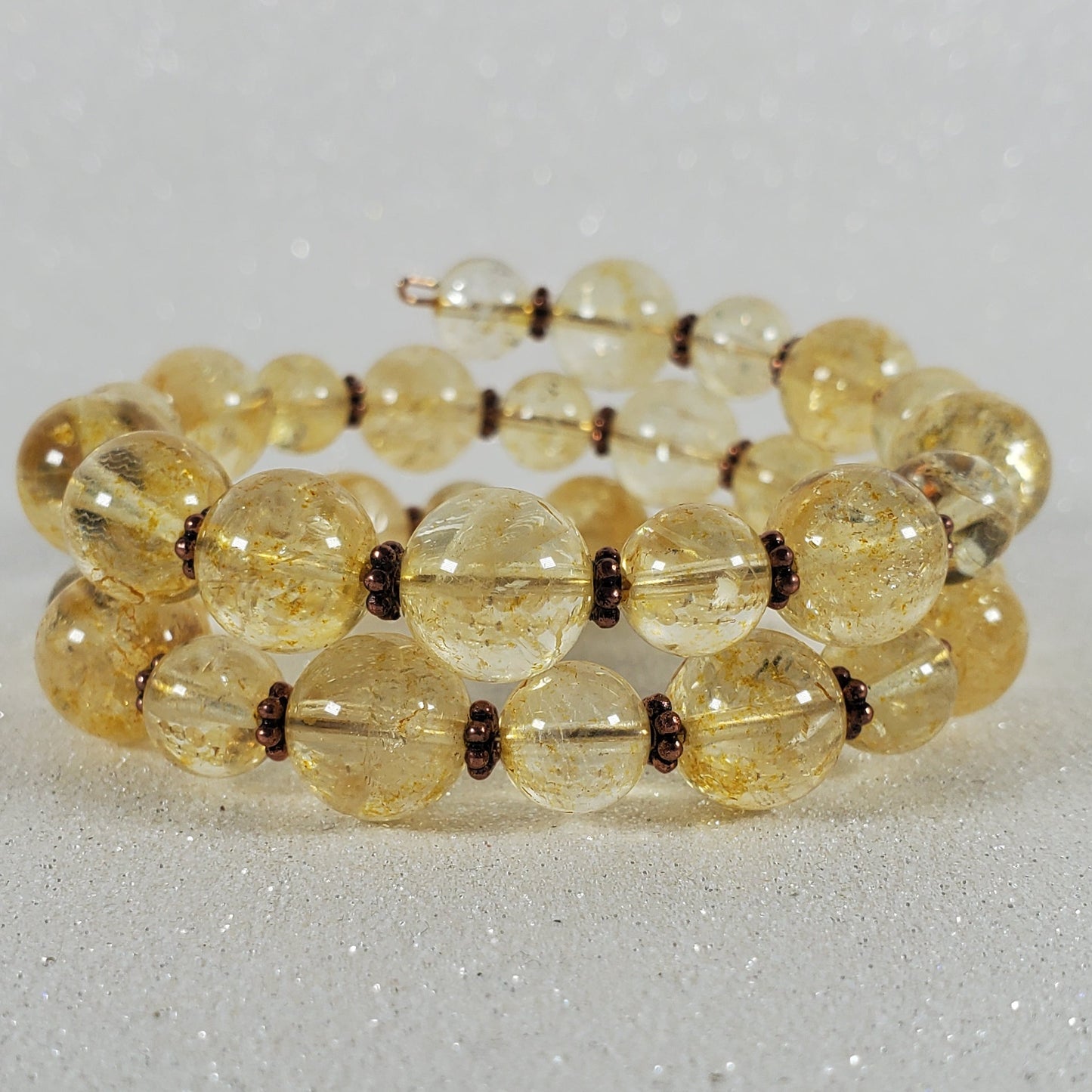 Beaded bracelet with yellow beads on a light gray background