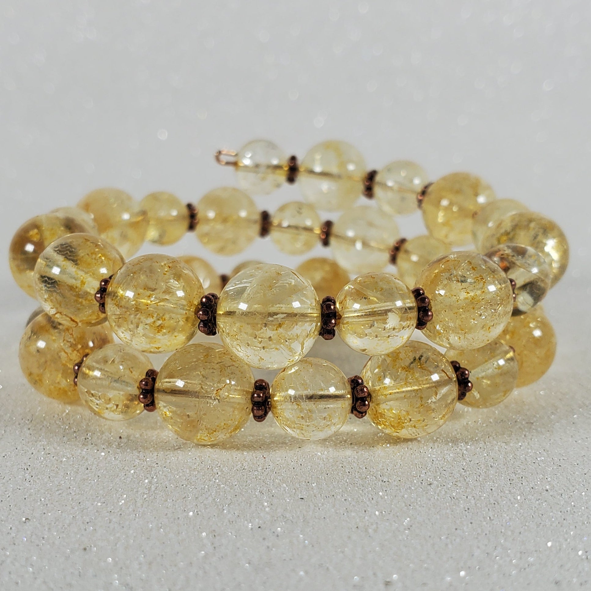 Beaded bracelet with yellow beads on a light gray background