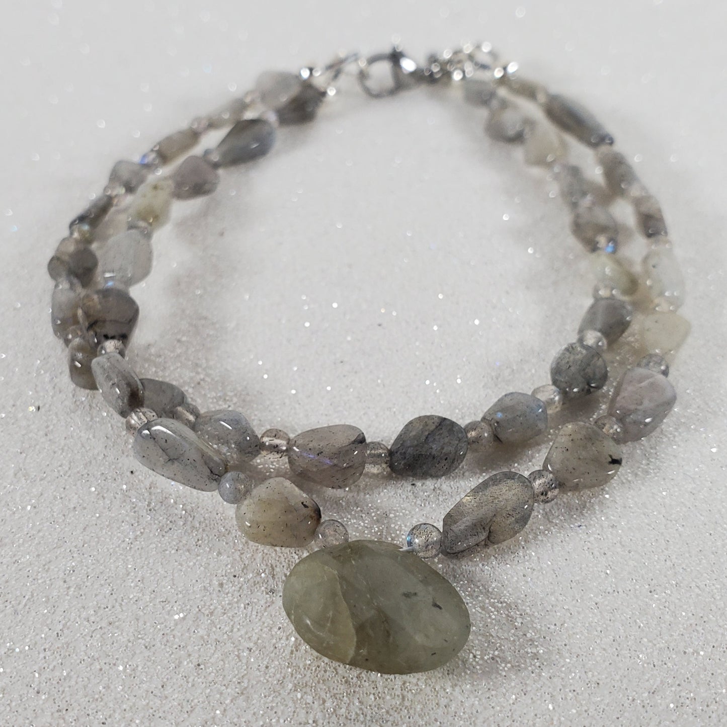 Two-layered beaded bracelet with a large central stone on a white background