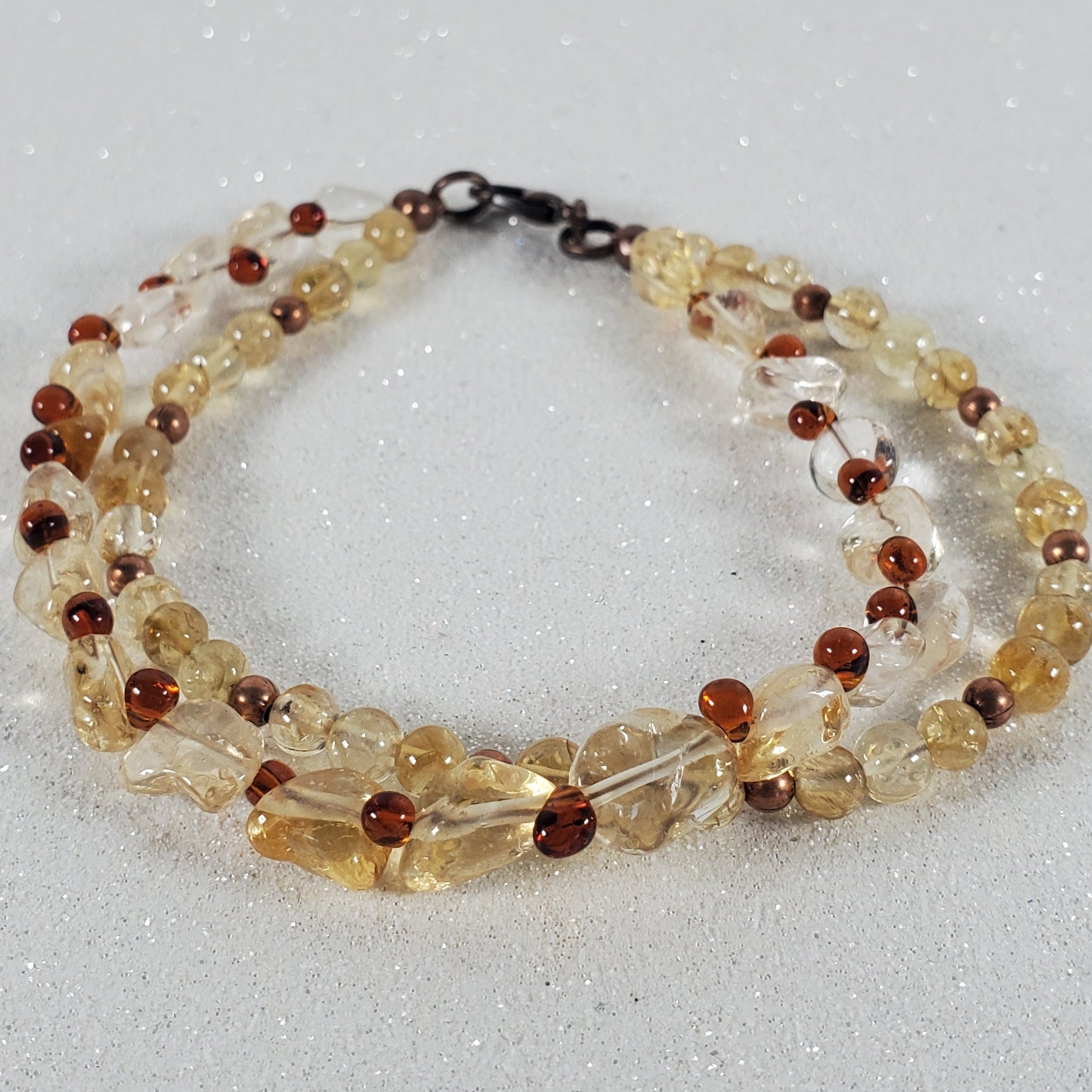 Beaded bracelet with clear and brown beads on a light gray background