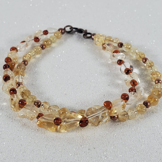 Beaded bracelet with clear and brown beads on a light gray background