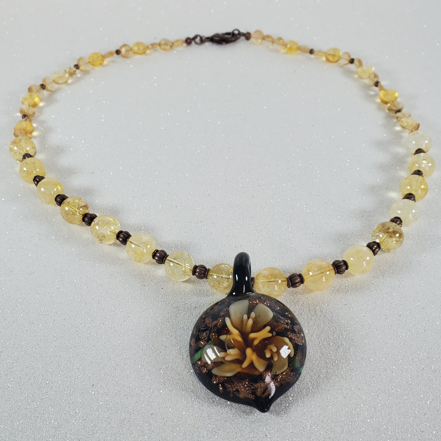 Necklace with yellow beads and a black clasp on a gray background