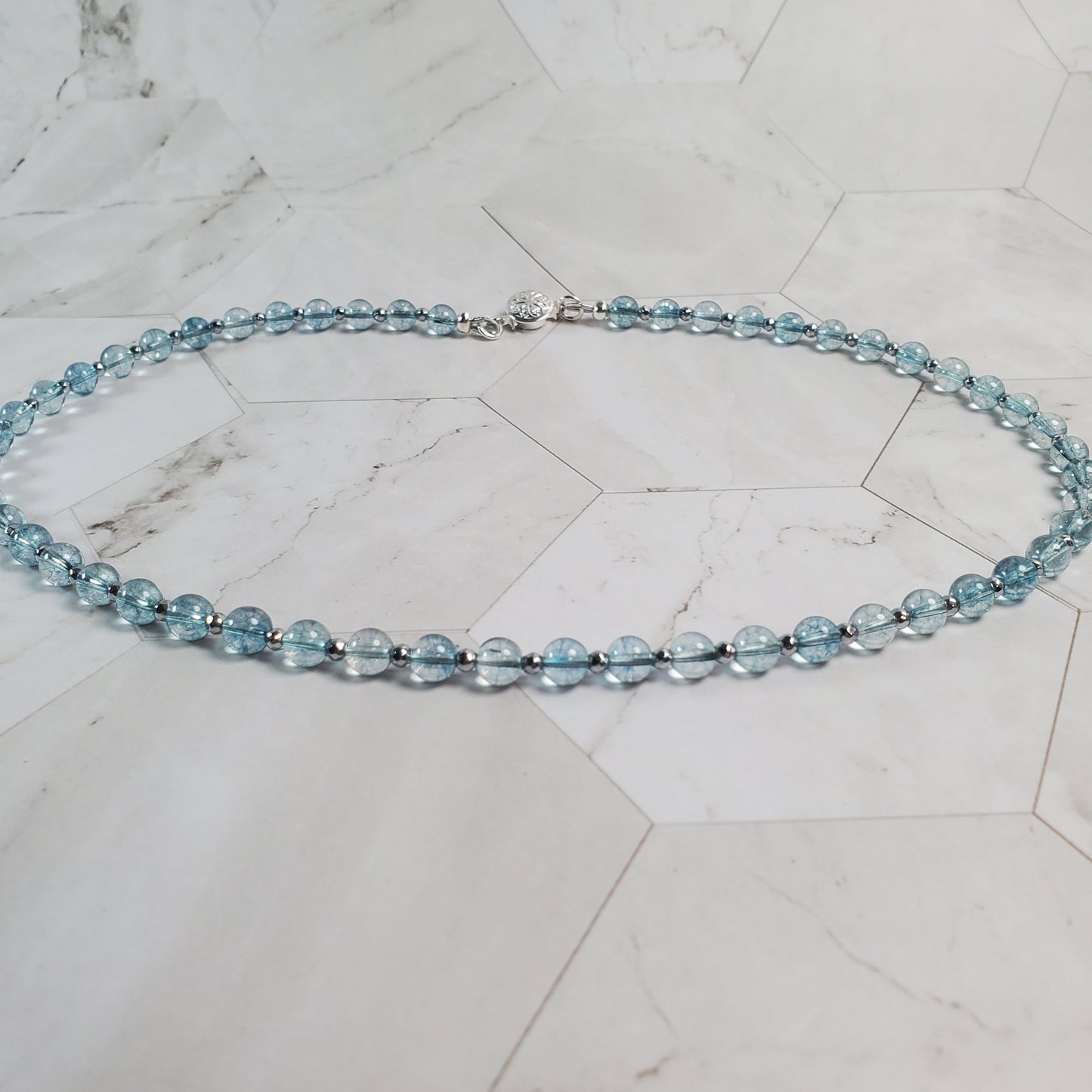 Necklace with blue beads on a marble surface