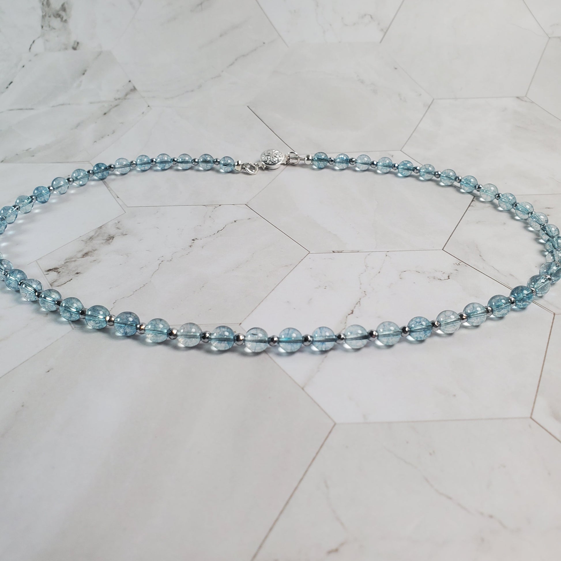 Necklace with blue beads on a marble surface