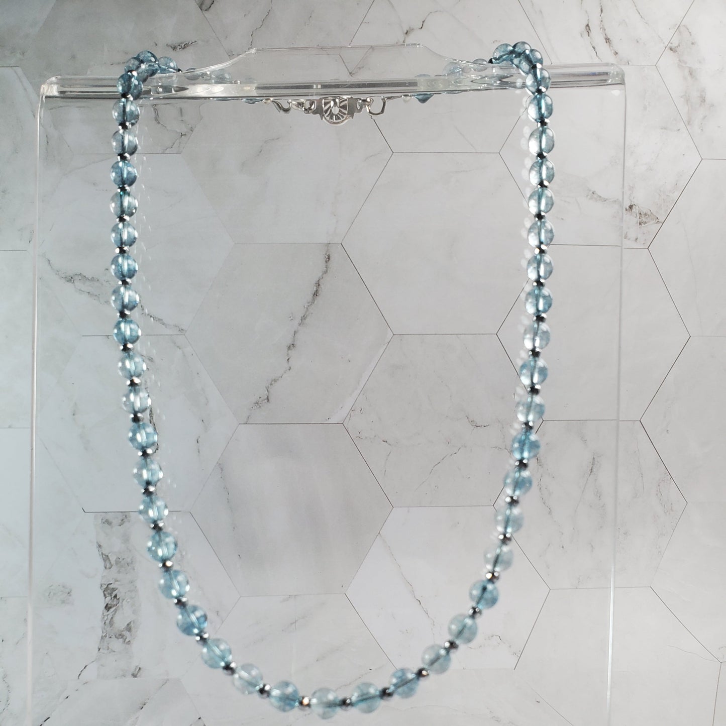 Necklace with blue beads on a marble surface