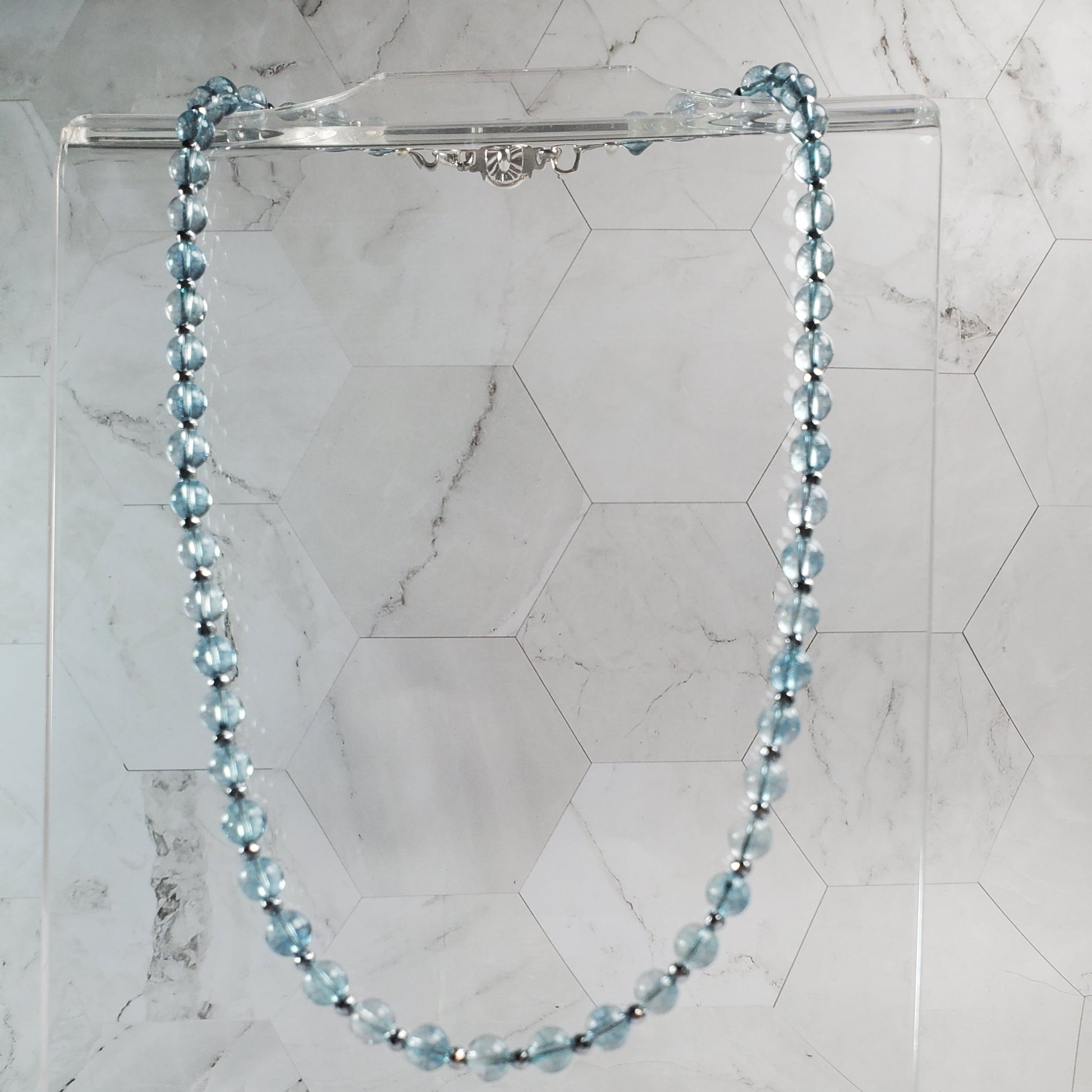 Necklace with blue beads on a marble surface