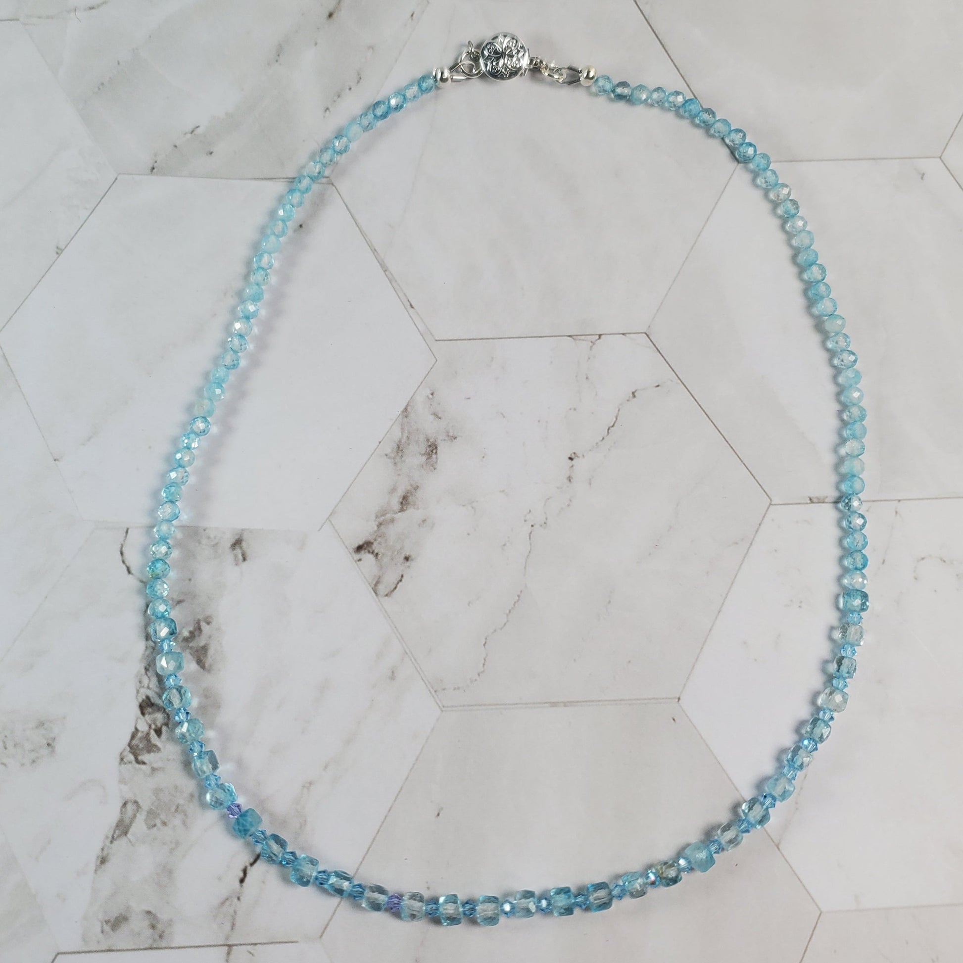 Necklace with blue beads on a marble surface