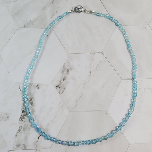 Necklace with blue beads on a marble surface