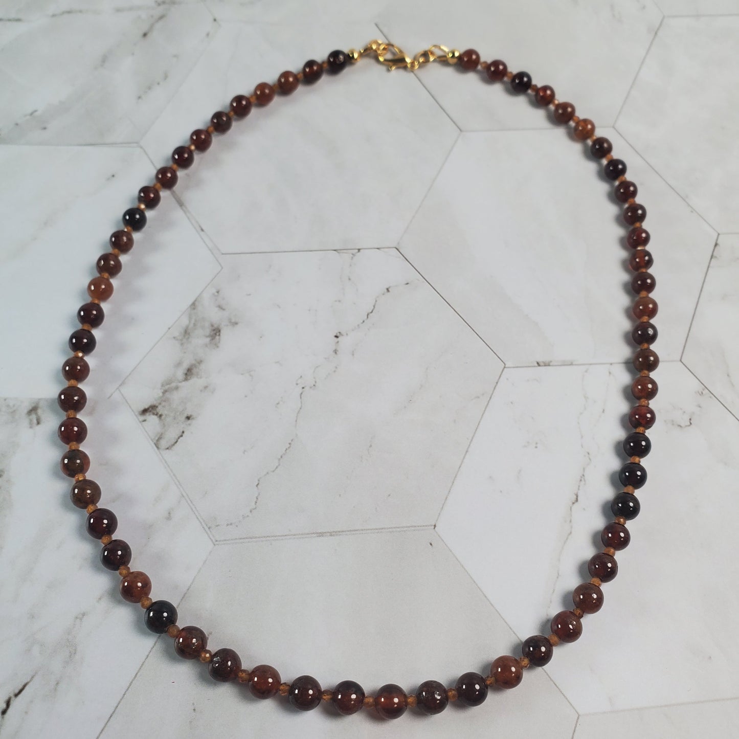 Necklace with brown beads on a marble surface