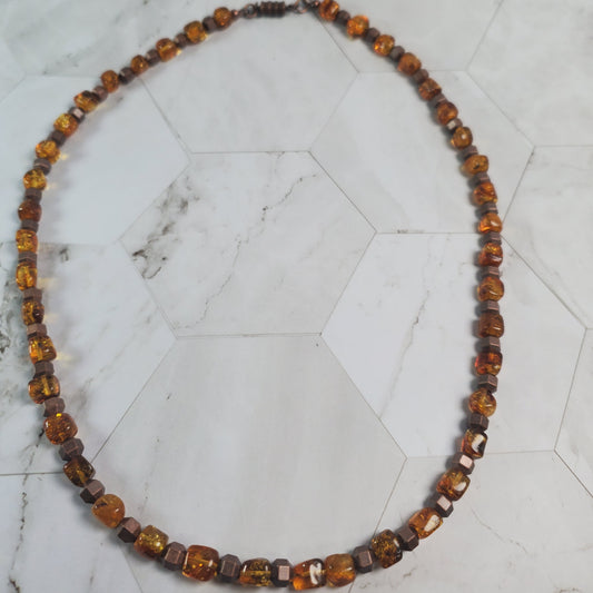 Necklace with topaz-colored beads on a marble surface