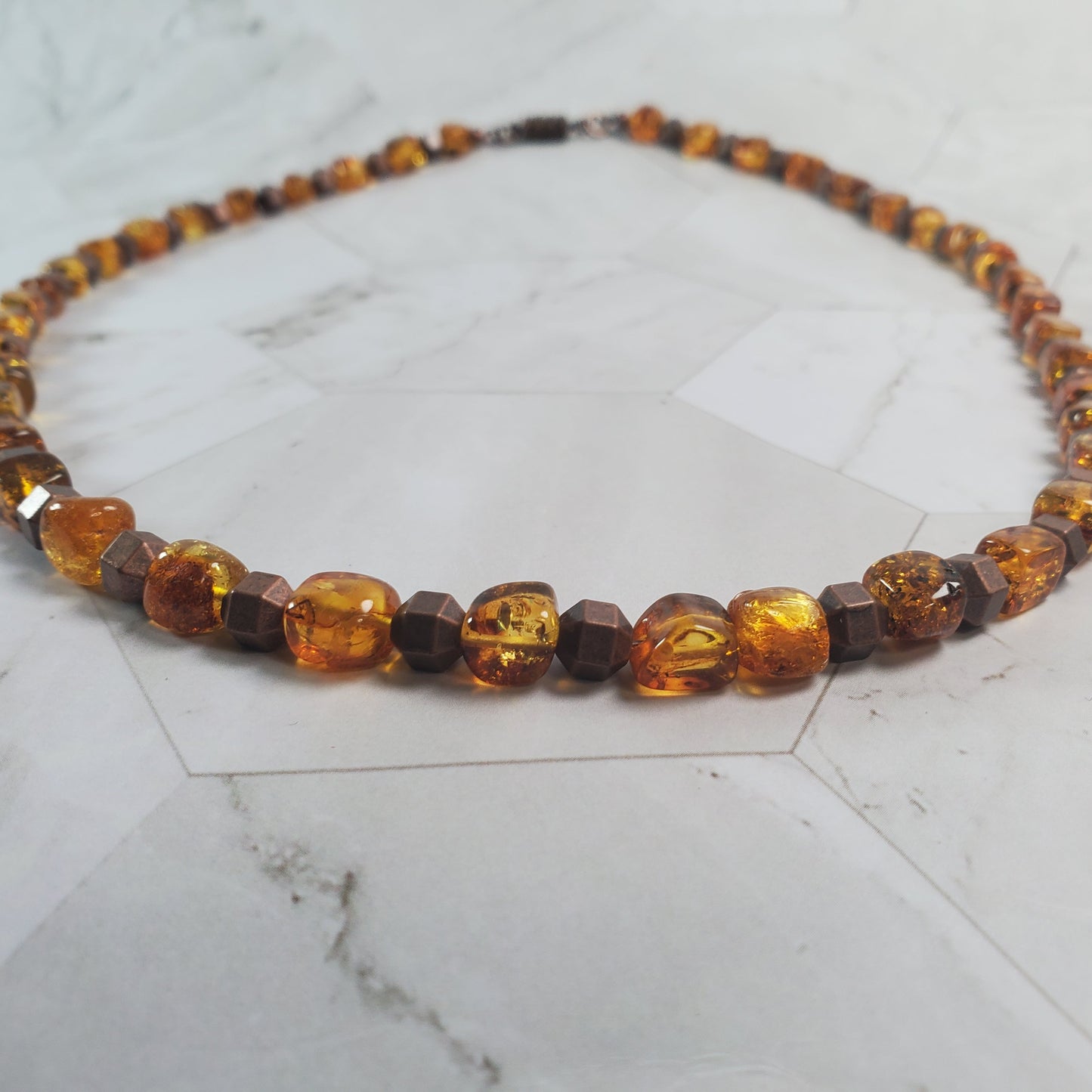Necklace with topaz-colored beads on a marble surface