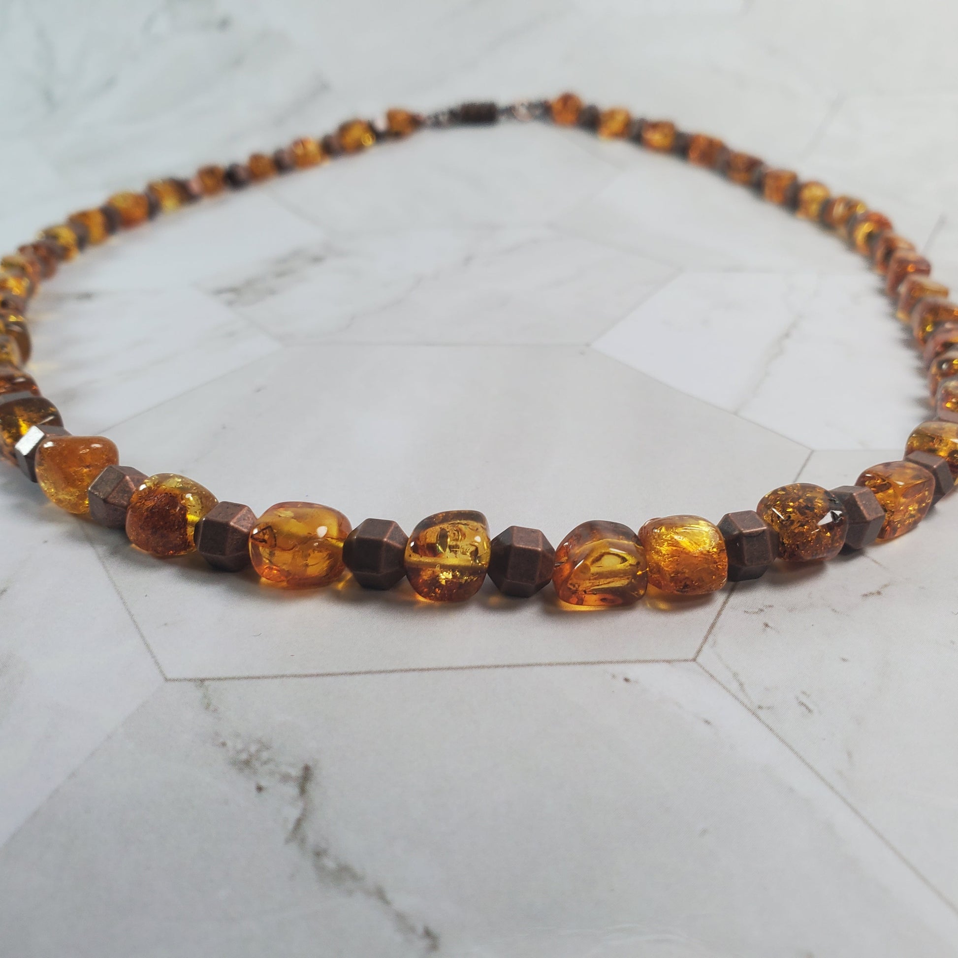 Necklace with topaz-colored beads on a marble surface