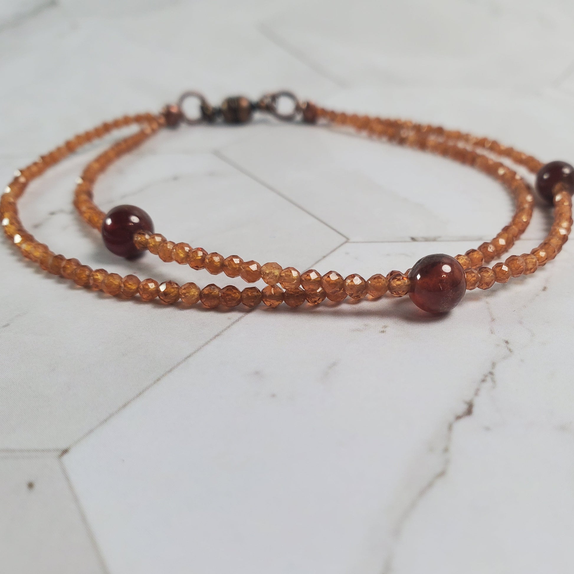 Beaded bracelet with brown and clear beads on a marble surface