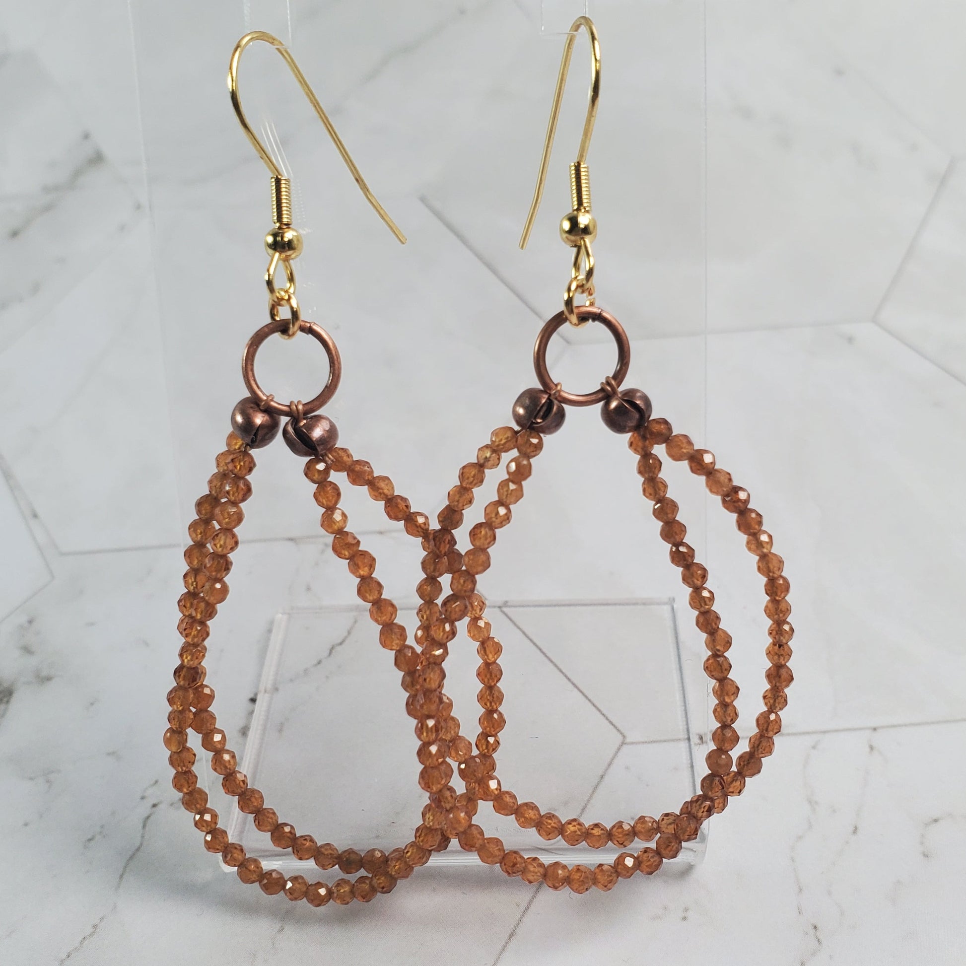 Beaded earrings with gold hook on a marble surface