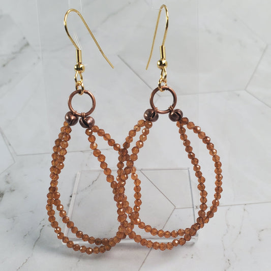 Beaded earrings with gold hook on a marble surface