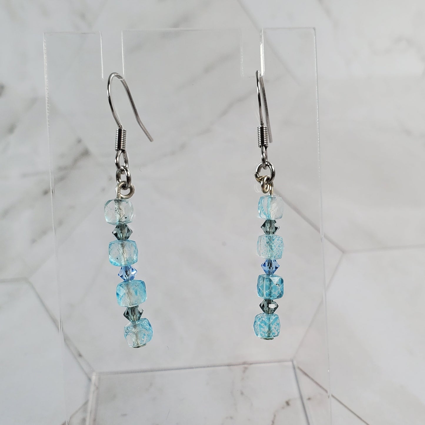 Pair of beaded earrings on a marble surface