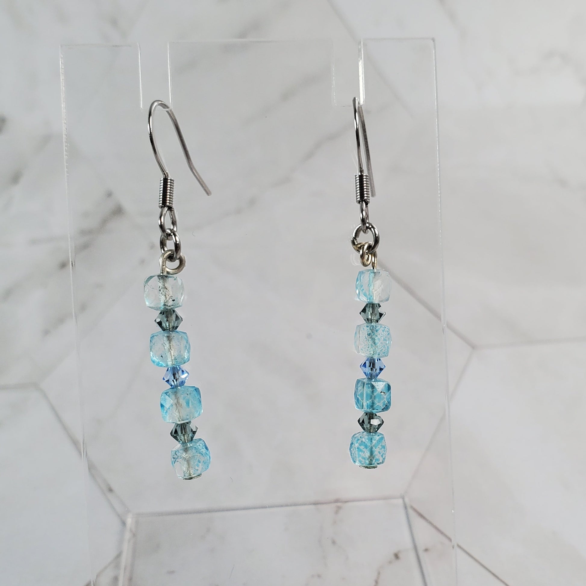 Pair of beaded earrings on a marble surface