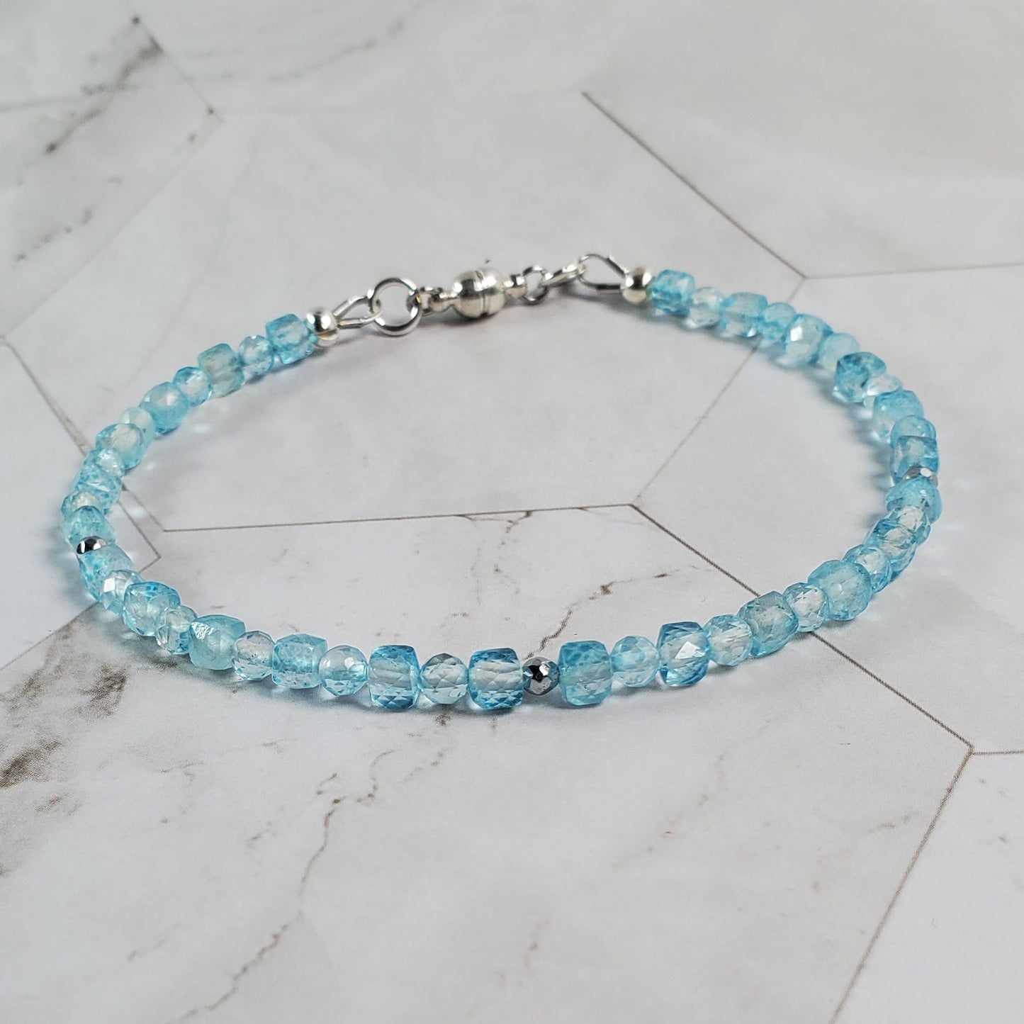 Blue beaded bracelet on a marble surface