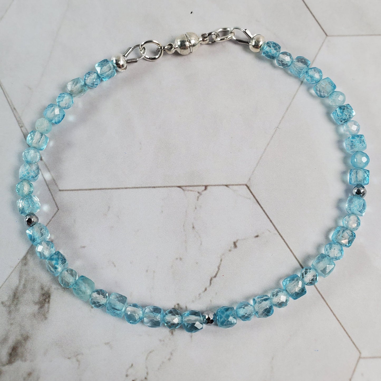 Blue beaded bracelet on a marble surface