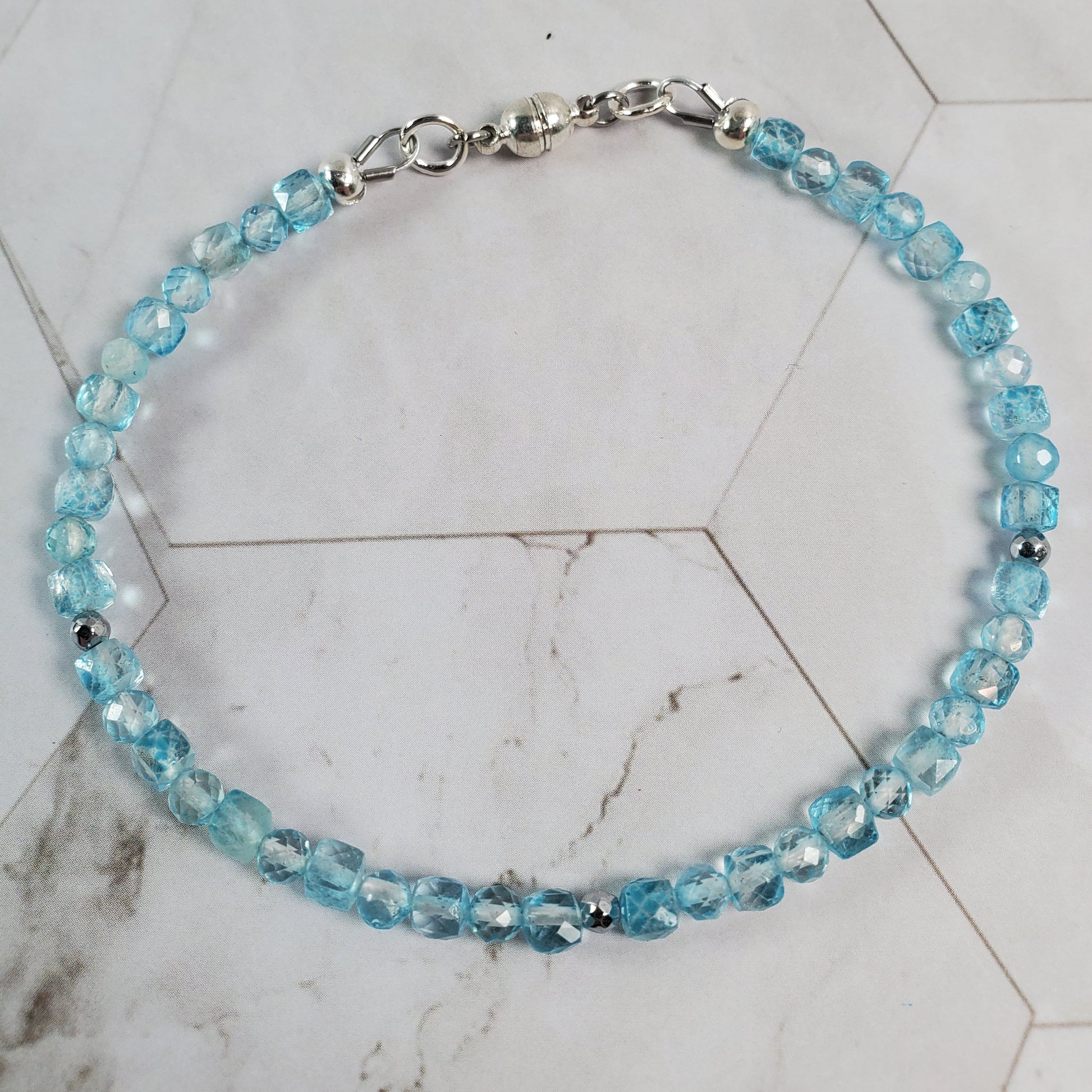 Blue beaded bracelet on a marble surface