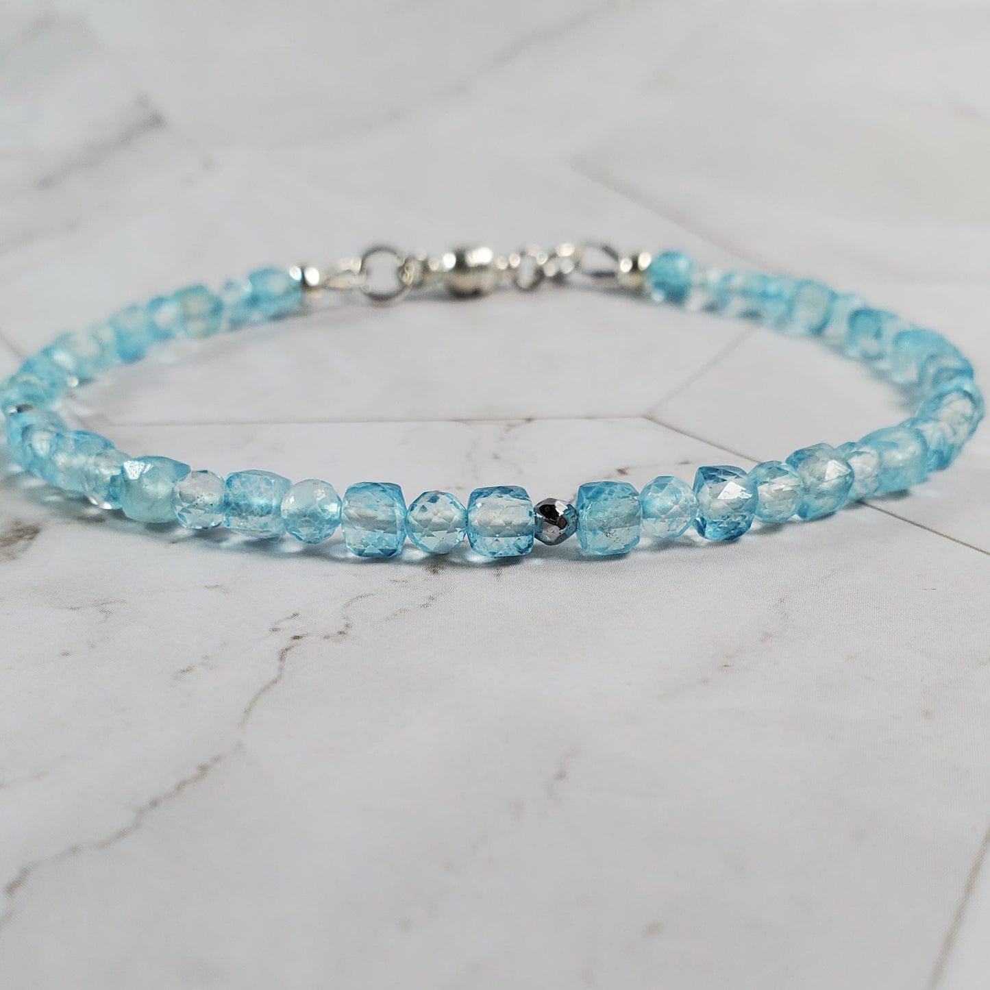 Blue beaded bracelet on a marble surface