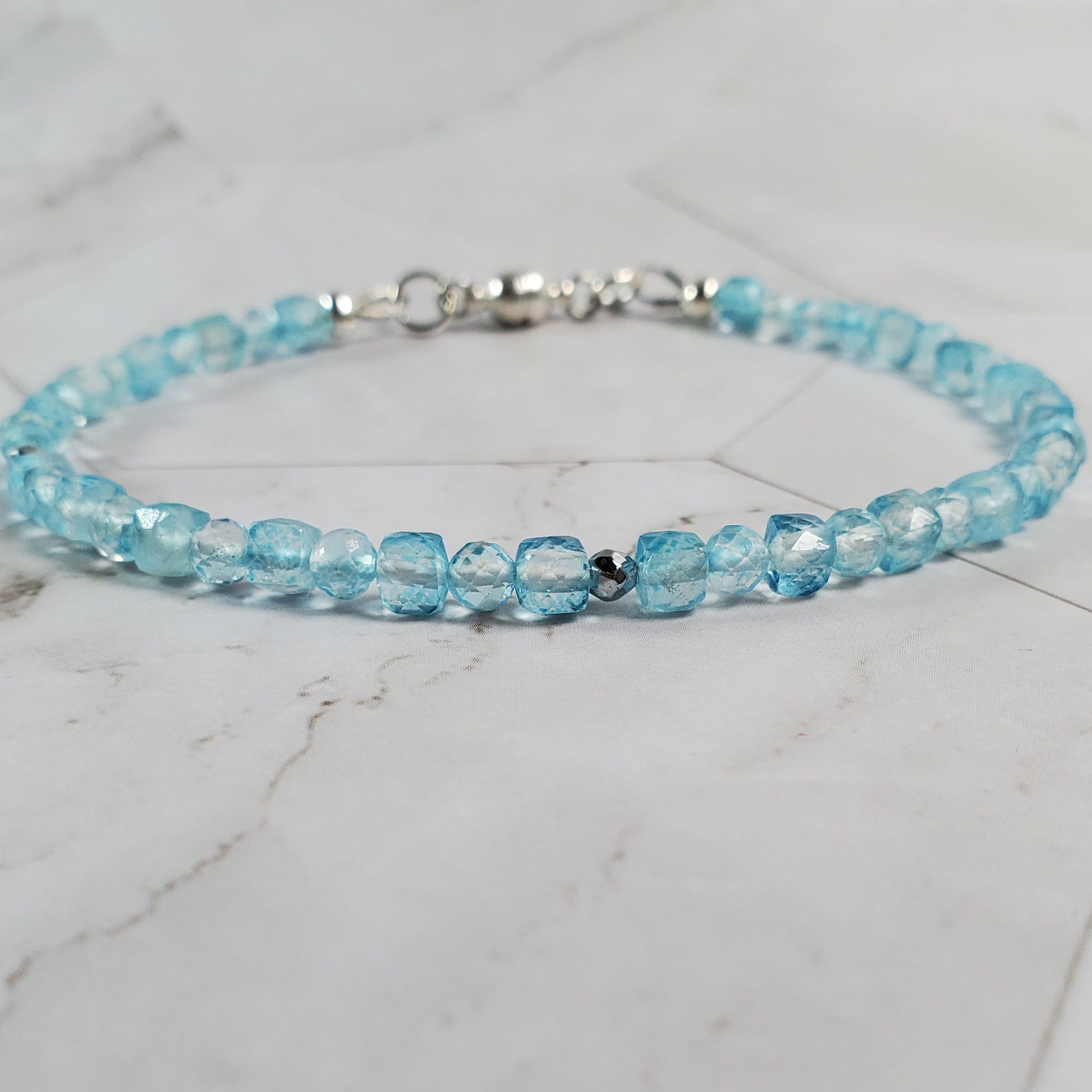 Blue beaded bracelet on a marble surface