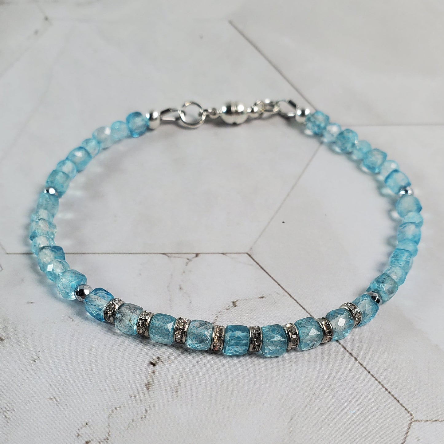 Blue beaded bracelet on a marble surface