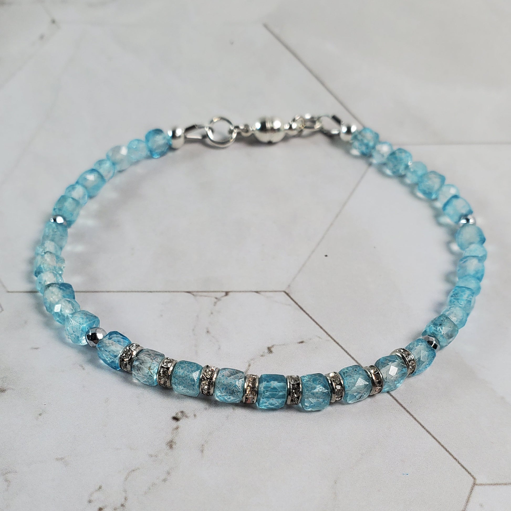 Blue beaded bracelet on a marble surface